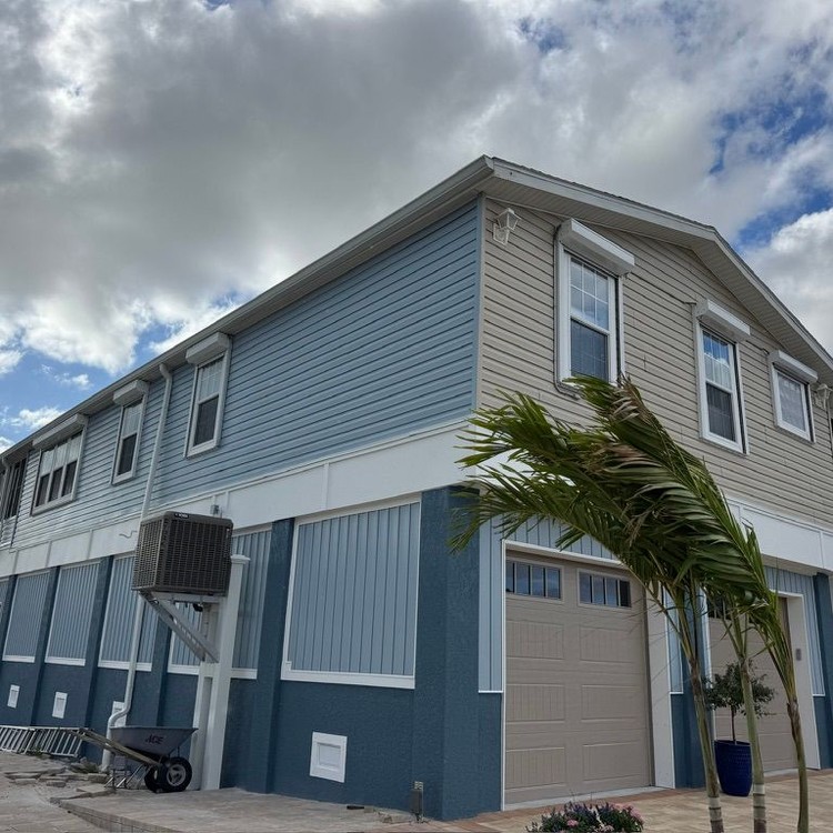 Two-story home with freshly painted blue and gray siding