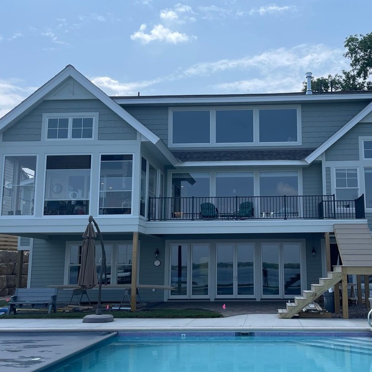 Freshly painted two-story home behind a backyard pool