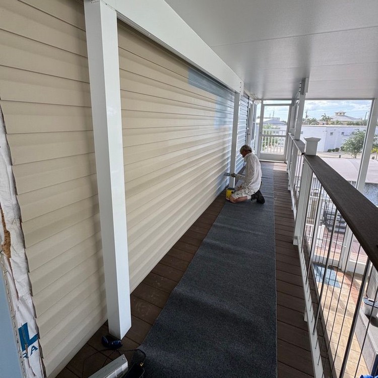 Painter working on a covered second-floor porch