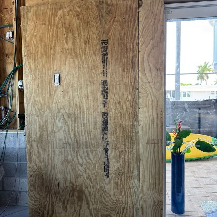 Framed pocket door opening covered in plywood